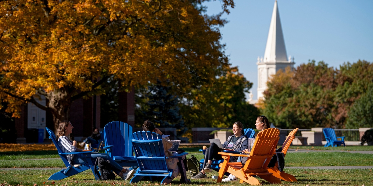 Students sitting in adirondack chairs on Malesardi Quad