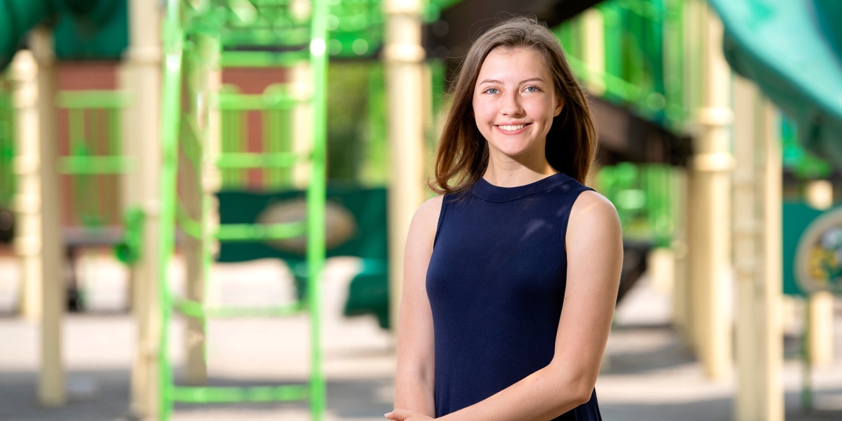 Brooke Ewer stands outside on a playground.