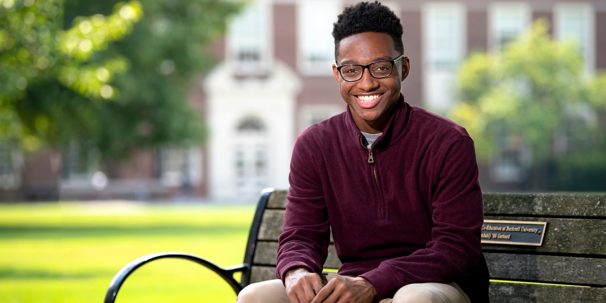 Quentin Andrews sits on a bench on Bucknell's campus.