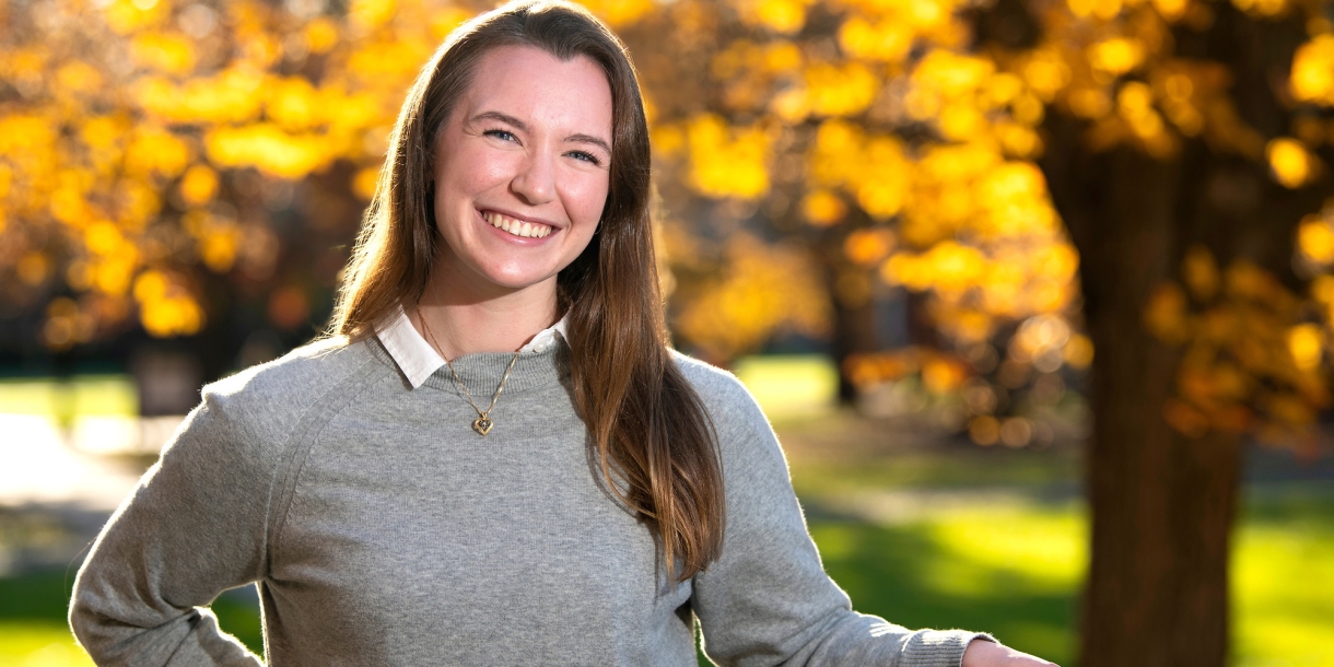 A student stands outside in the fall on Bucknell's campus