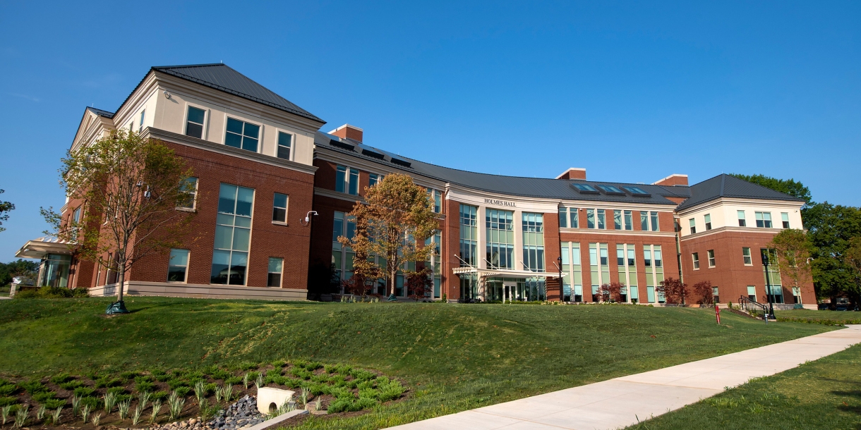 Exterior of the building Holmes Hall on a blue sky day