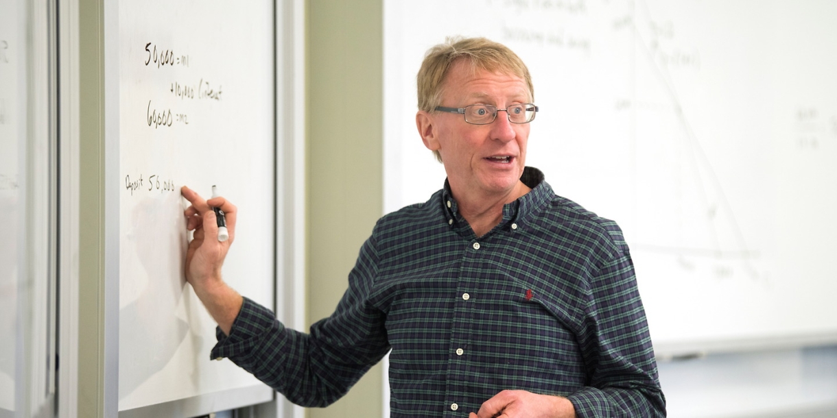 Professor Kinnaman pointing at a whiteboard