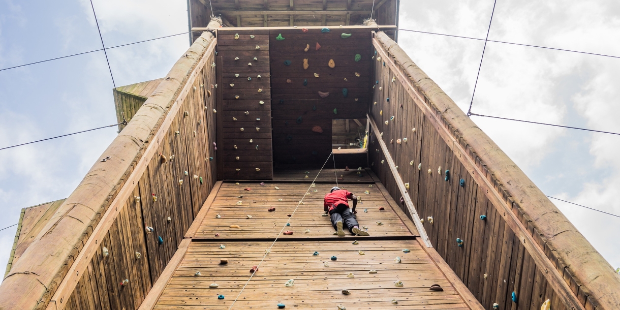 Student climbing rock wall