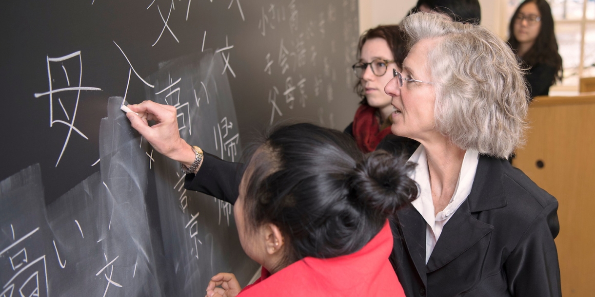 Elisabeth Armstrong writing on a chalkboard