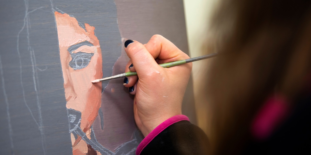 A painter meticulously creating a face on canvas