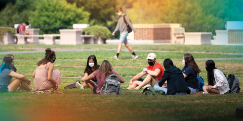 Masked students sit on Bucknell's quad.