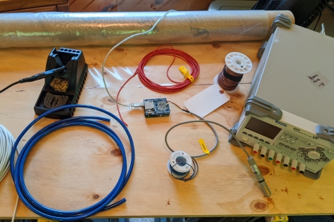 Wiring, plastic sheeting and an oxygen concentrator displayed on a workbench.