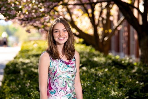 Lily Shorney &#039;22 stands under the cherry blossoms.