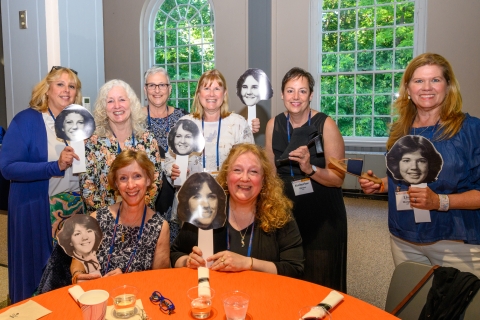 Class of 1982 group photo of women holding college photos of themselves