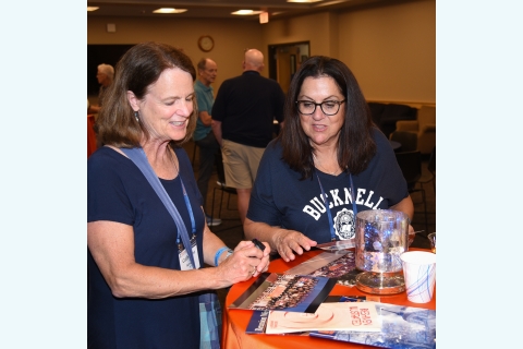 Two women looking at past photos and booklets