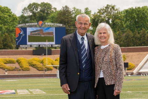 Michael and Jocelyn Pascucci are pictured in front of the video board bearing their family&#039;s name.