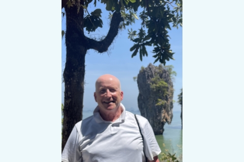 Kurt Waters '77 stands and smiles with Khao Phing Kan in the background.