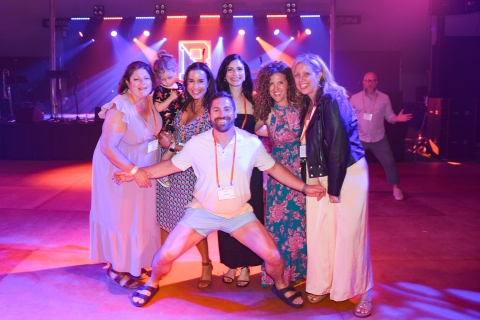 A group of alumni gather on a dance floor.