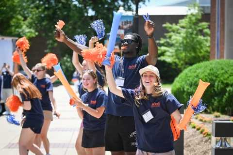 Reunion Ambassadors wave pom-poms and cheer.
