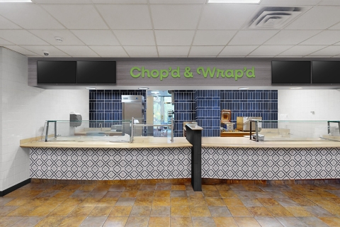 An eatery counter with the sign Chop'd & Wrap'd in the Bison Cafe.