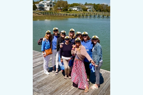 a group of Bucknellians stand on a dock together wearing captain's hats