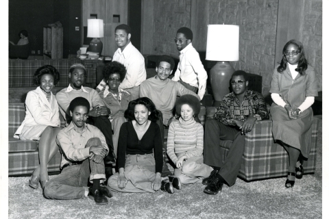 An archival photo shows a group of black students smiling at the camera. 