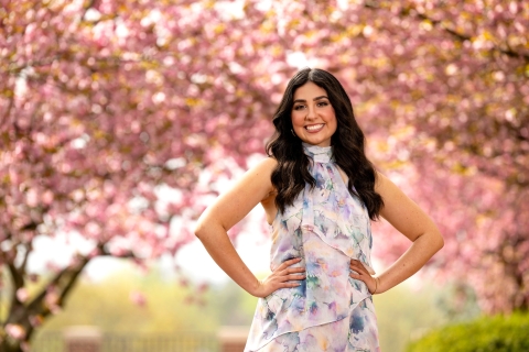 Alexandra Slofkiss &#039;24 poses outdoors among cherry blossom trees in bloom.