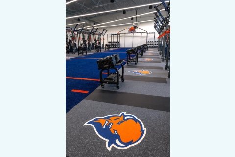 The weight room in the Pascucci Team Center features a blue truf run and bison logos on the floor