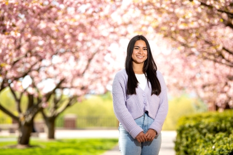 Adriana Gudiel-Matehu poses in front of cherry blossoms.