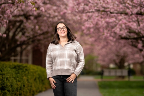 Isabell DiGiulio poses in front of cherry blossoms