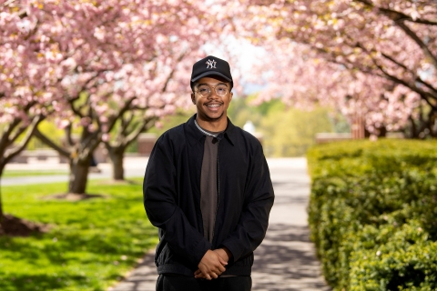 James Andradas '23 poses in front of cherry blossoms