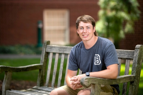 Portrait of Jonathan Hayes &#039;21 sitting on bench