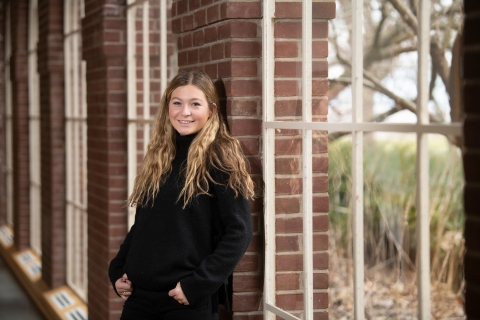 Olivia DeNicola stands in front of a window.