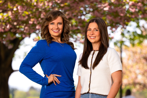 Katie Fitzgerald ’26 wears a blue dress while standing next to Sinclair Stevens ’26, who is wearing a white top. 