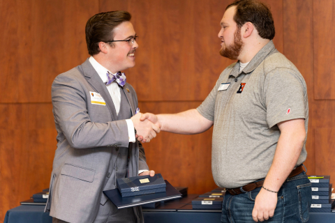 Graiden Allen ’29 shakes the hand of Josh Katz while holding an award.