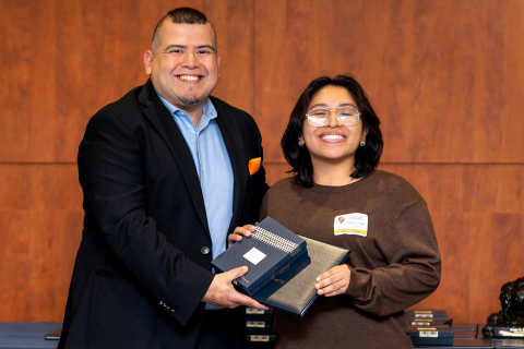 Valeria Lopez smiles as she accepts an award from Tomas Sanchez