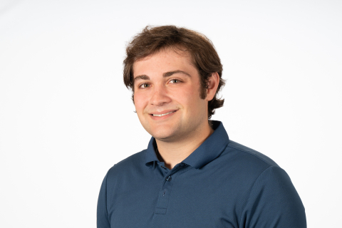 Noah Kerzner smiles against a white backdrop