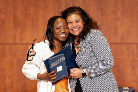 Caro Mercado side-hugs Marie Victorie Alexis and they both smile.