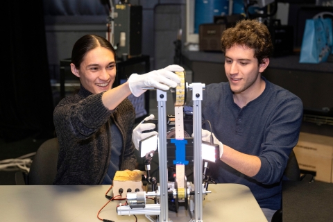 Jackson Rubiano '27 and Harry Winter '26 wear white gloves as they handle delicate paper films.