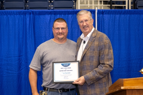 Tom Foerster and John Bravman stand together and smile while holding a certificate