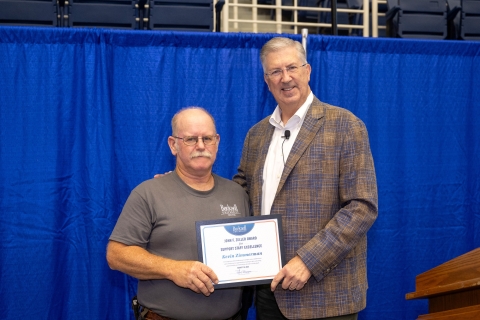 Kevin Zimmerman and John Bravman stand together and smile as Bravman hands Zimmerman a certificate