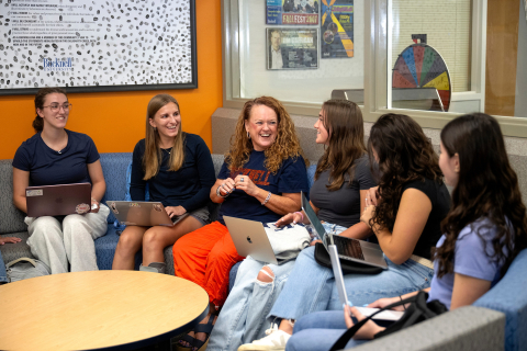 A group of students sits smiling with Moe McGuinness, Fritz Family Dean of Students.