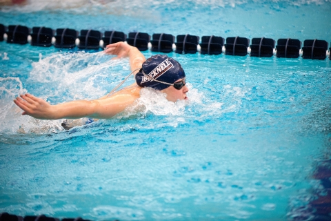 Person in a pool swimming the butterfly stroke. 