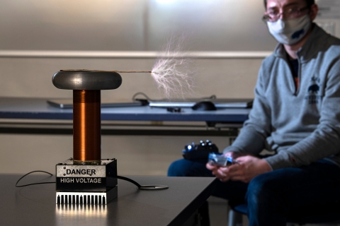 David Berry sits inside with his musical Tesla coil
