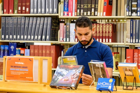 Student reading a book in the library.