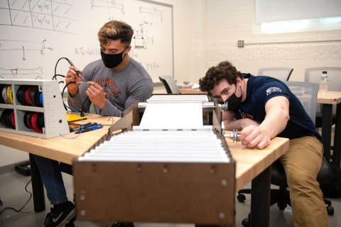 Mechanical engineering majors Michael Bortolot '21 and Nate Romanowski '21 assemble their prototype sanitizing device