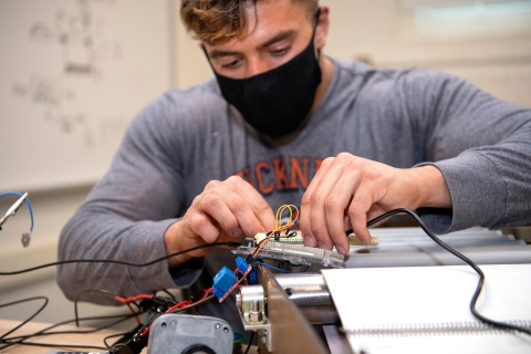 Michael Bortolot connects wires on the sushi sanitizing device