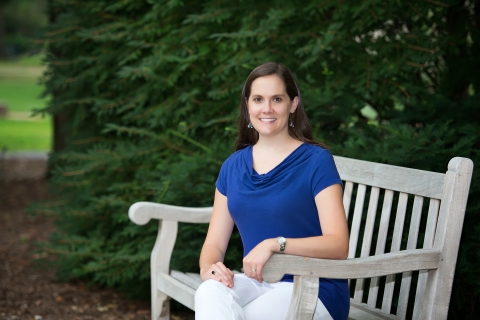 Professor Lara Dick sits on a bench outside.