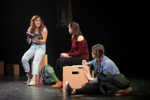 Three actresses sit on stage talking.