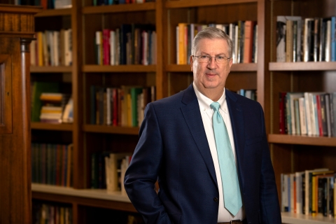 Portrait of President John Bravman in a library