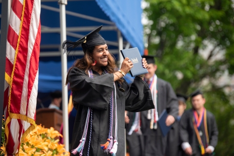 Graduate presenting her diploma to the crowd