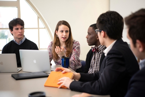 Students discuss around a conference table
