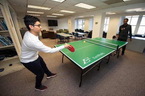 Students playing ping pong in common room