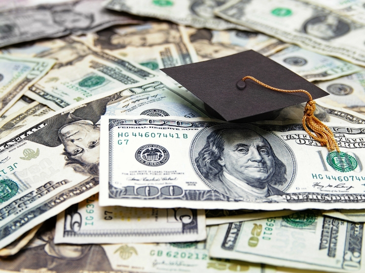 Money laid out with a graduation cap on top.