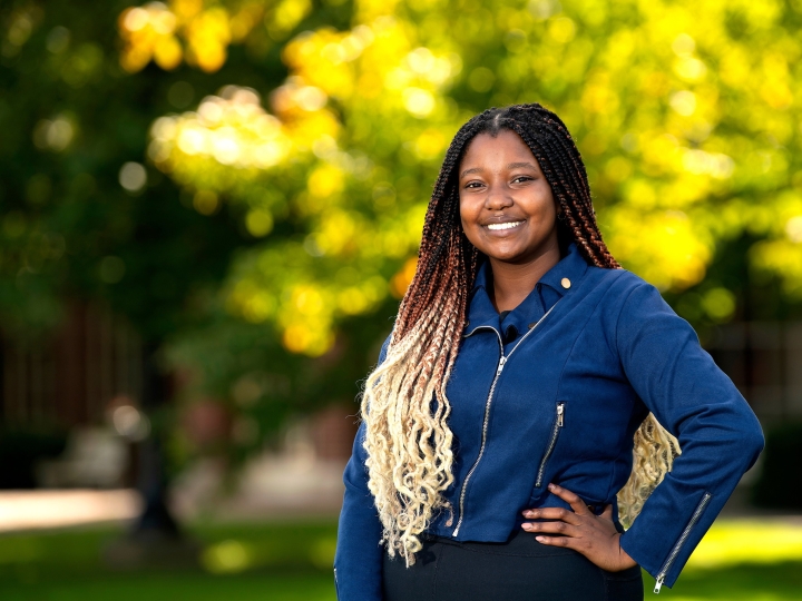 Twity Gitonga poses in a denim shirt and black pants Malesardi Quadrangle.